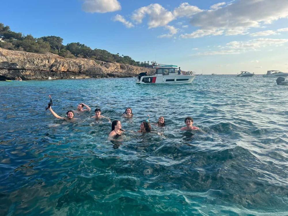 Eight students swimming in bright blue water on a snorkeling trip