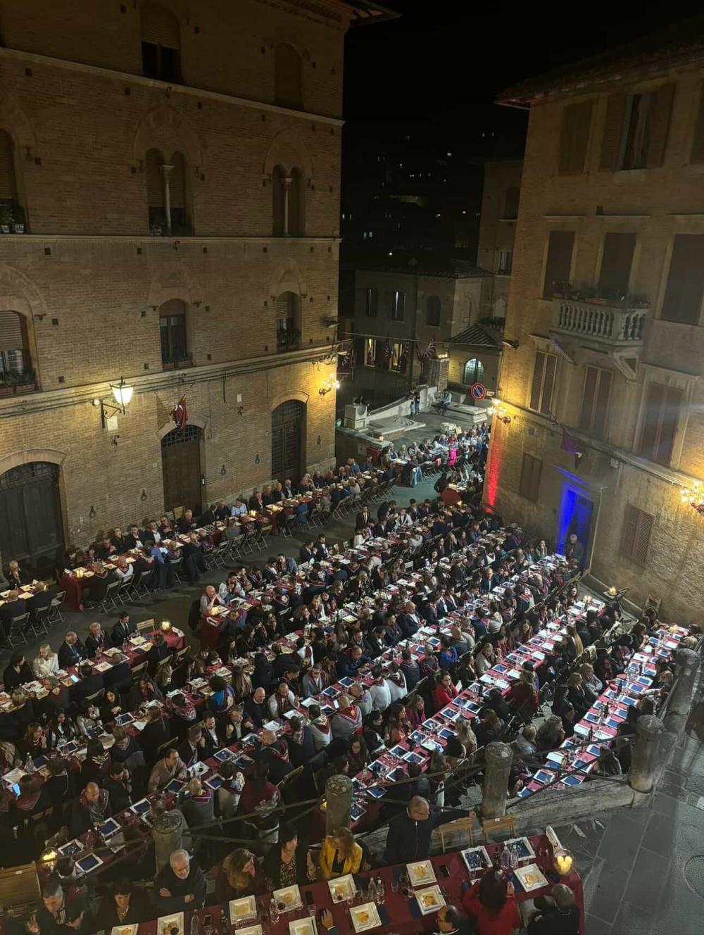 Italian street at night filled with locals dining and celebrating a holiday.