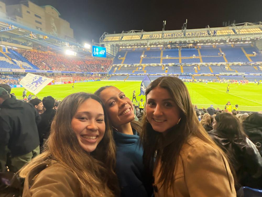 Hana taking a selfie at the Chelsea Football Club in England with two other students
