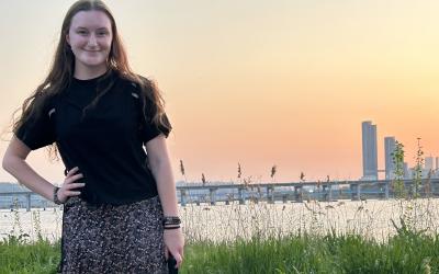 Student Zoe Tomlinson posing in front of the Tokyo skyline