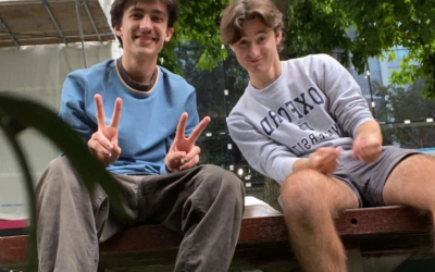 Two young men sit on a bench