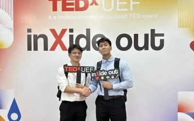 Two young men stand at a TED Talk event