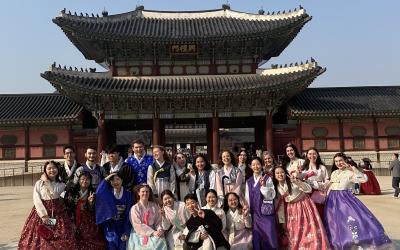  Group of people in traditional Korean hanbok dresses posing for a photo at Gyeongbokgung Palace in Seoul.