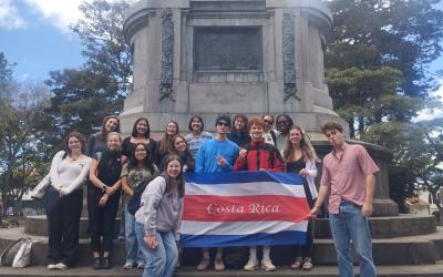 Group of about 10 students stand with a Costa Rica flag