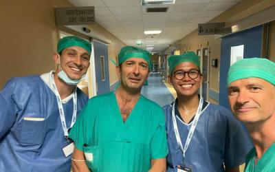 Densel smiling with three doctors in scrubs in an Italian hospital