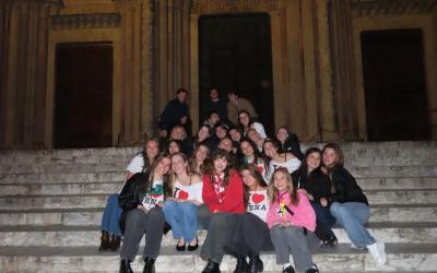 GEO students smiling for a photo on the steps of a church in Siena, Italy at night