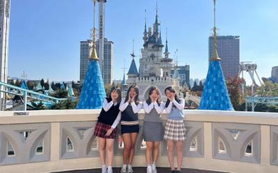 Four students posing on a roof in Seoul with their hands framing their faces
