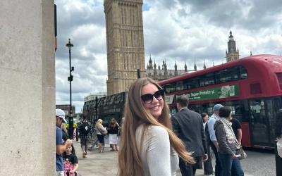 Jordan smiling with sunglasses near the Big Ben in London on a cloudy day