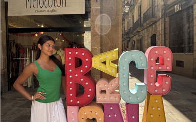 A uo student standing next to a Barcelona sign on the street