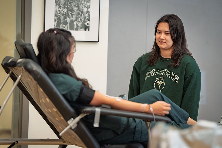 Kaylin Kisor speaking with a student in a chair
