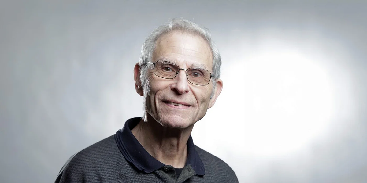 grey hair man smiling on a solid grey background