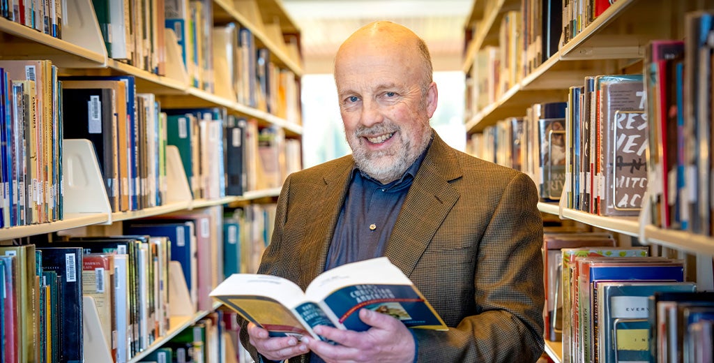 Scott Drumm holding book in library