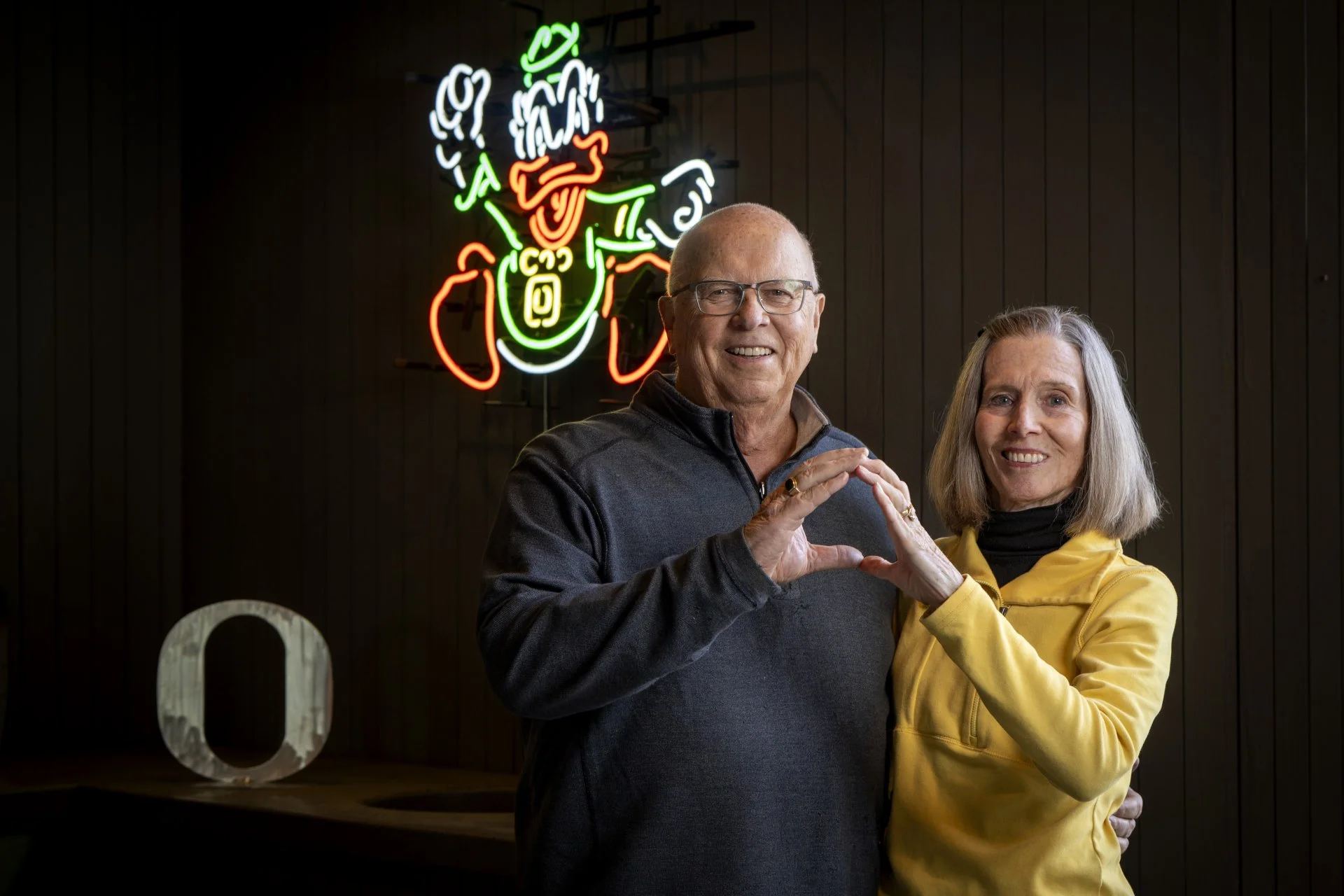 Nancy and Don smiling while making the Oregon symbol with their hands