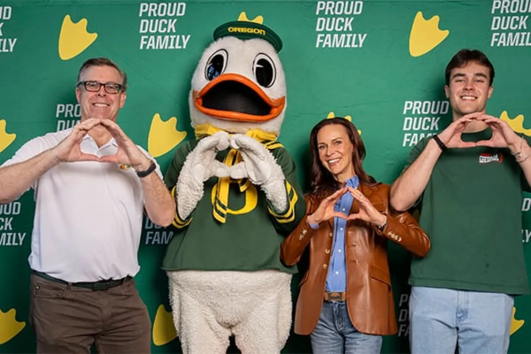 Brook and Aaron Shelby with son and Duck in front of yellow "O"