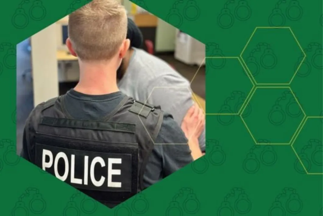 A student shown from the back wearing a police vest