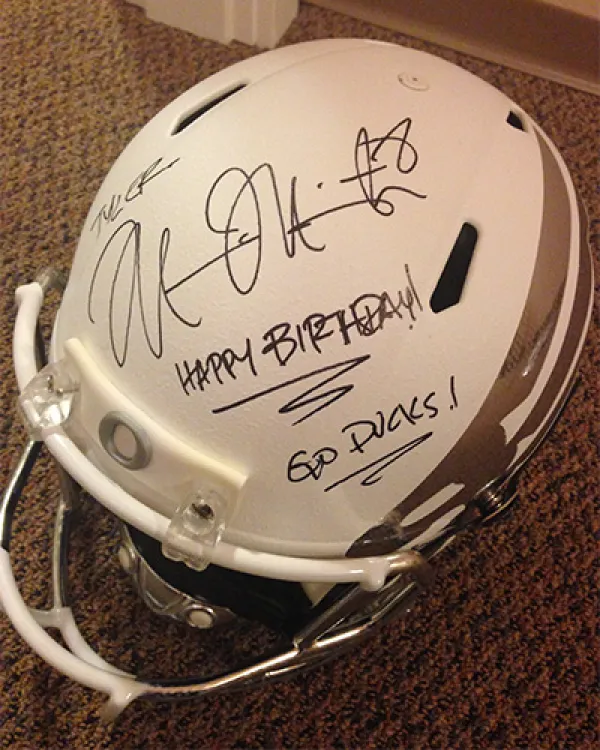 Oregon football helmet with a signature and a message saying "Happy birthday! Go Ducks!"