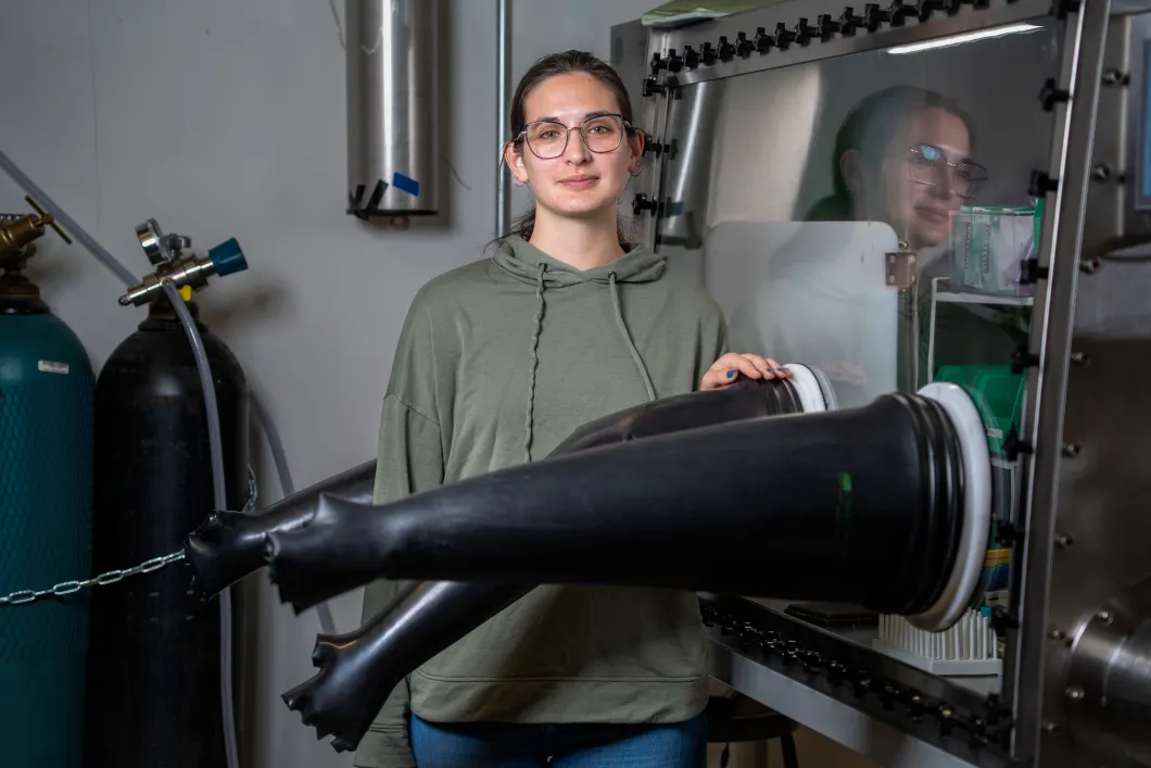 Allison LaSalvia stands next to scientific machinery