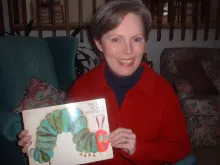Jane Eliason holds a copy of the Very Hungry Caterpillar