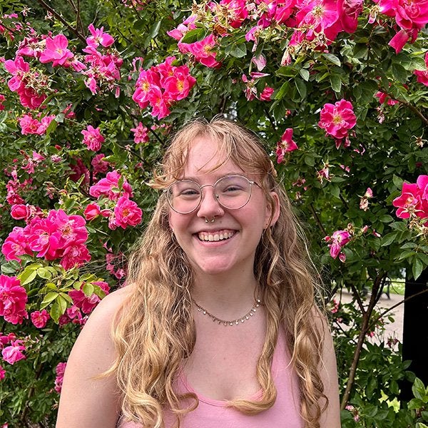 Student in front of pink flowers