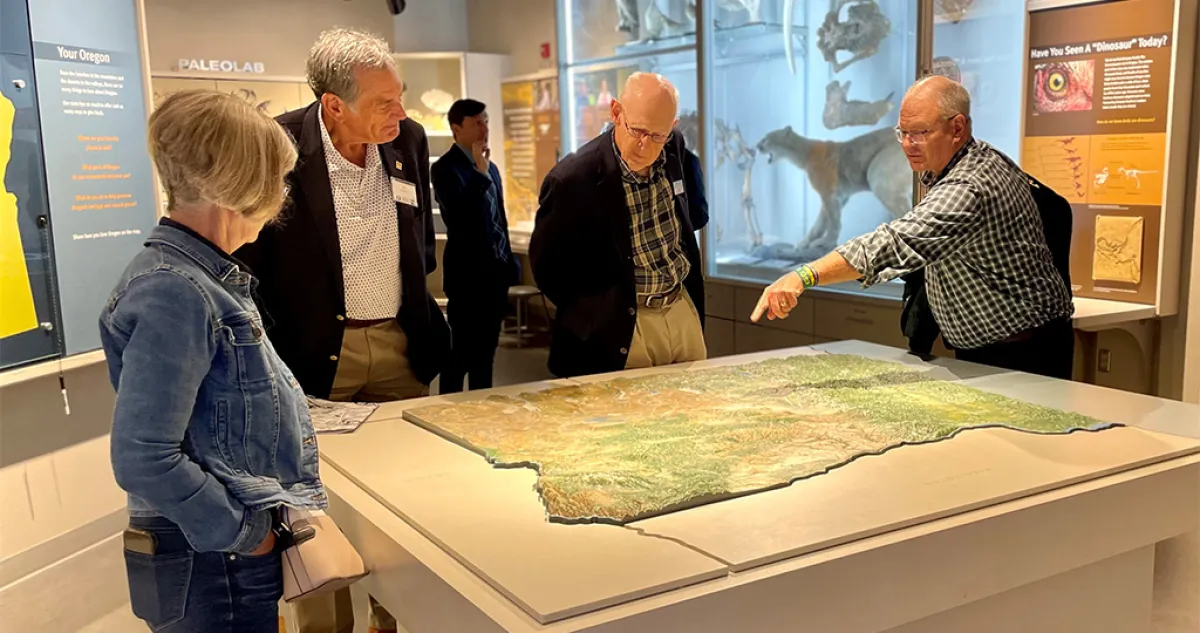 Several older adults standing around a display in a museum