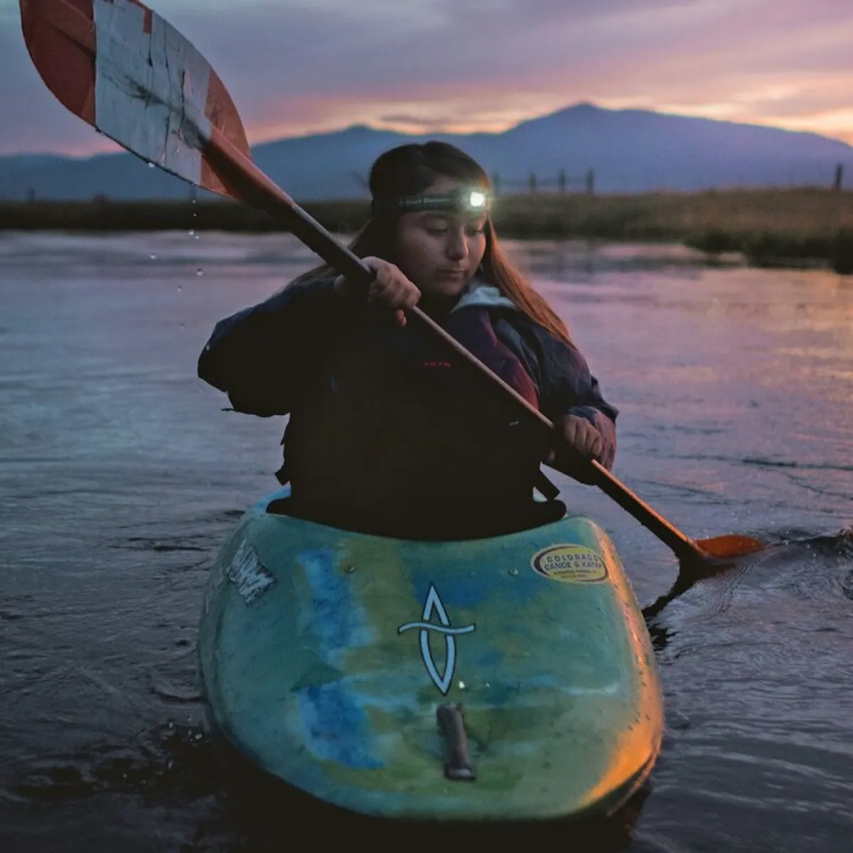 Photo of UO student Ashia Grae Wolf Wilson in a kayak at dusk