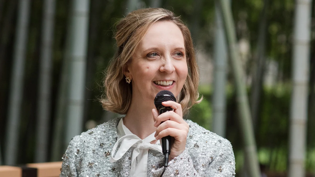 woman smiling and holding a microphone