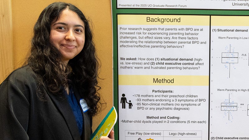 Graduate student presenting a poster of their research.