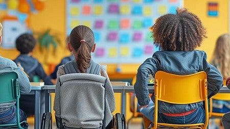 students at their desks in a classroom, see from behind