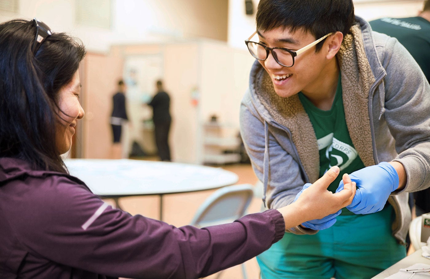 A Duck Corps student is taking a blood sample from a community member at Die de Salud.