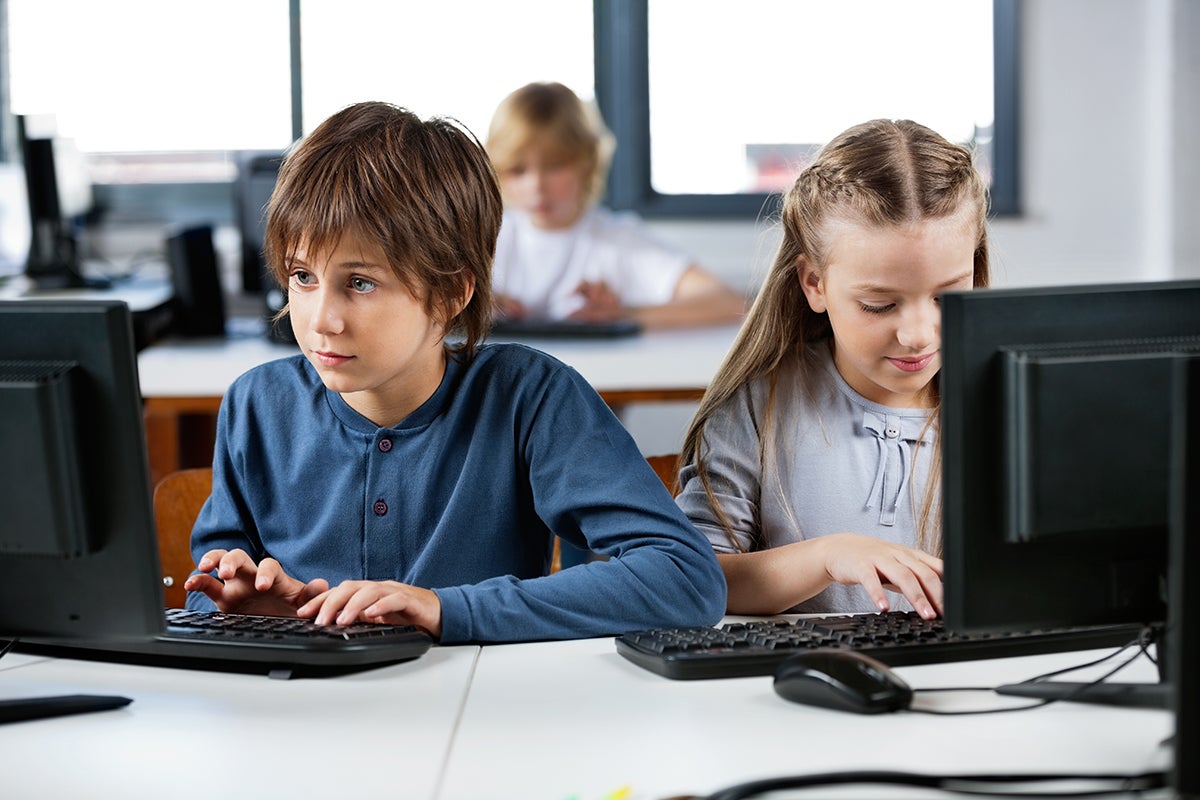 Children using keyboard on computer.
