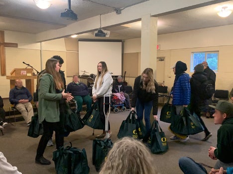 Students giving out UO Branded reusable bags.
