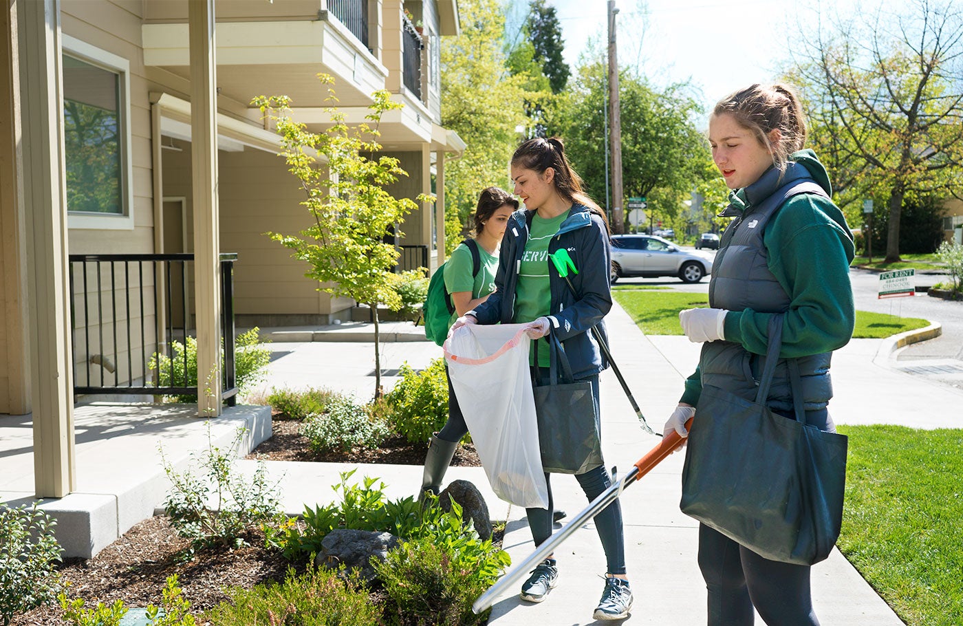 Students picking up trash from neighborhood sidewalks.