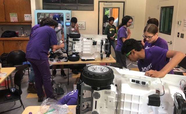 Students modify children's power cars.