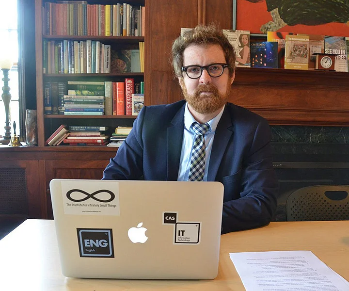 Matthew Hannah at a workstation with a computer, facing the camera.