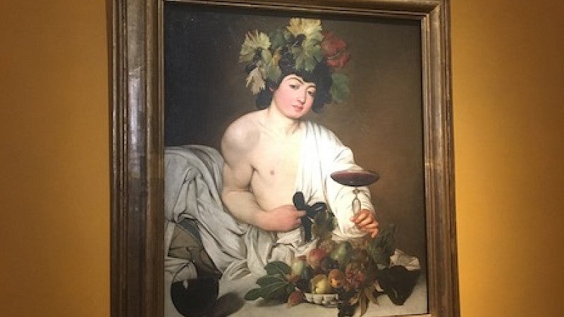 Painting of person in toga with grapevines and wine