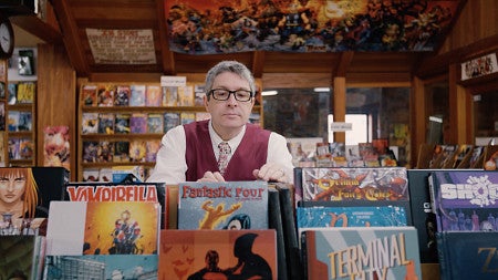 Pofessor Ben Saunders browsing comic books in a store. 