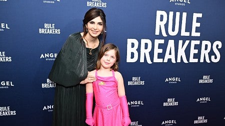a woman and girl pose for a photo on the red carpet at a moview premiere