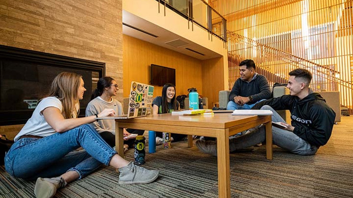 Students sitting around a table talking. 