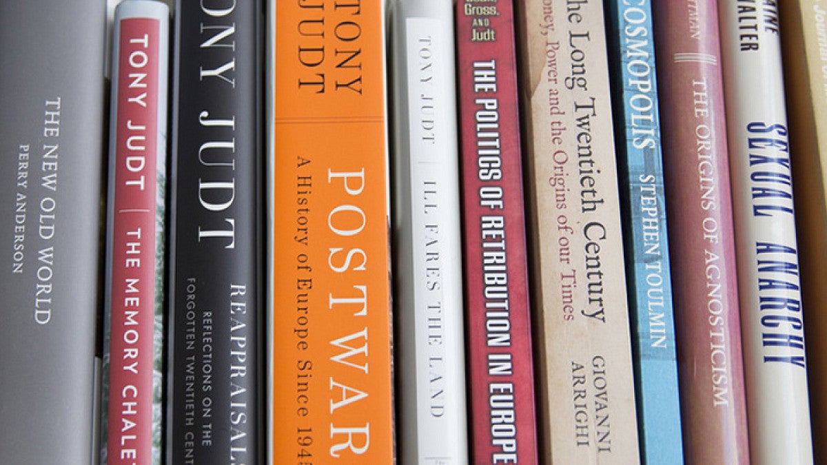 Vertically stacked books standing on a shelf, possibly recent publications.
