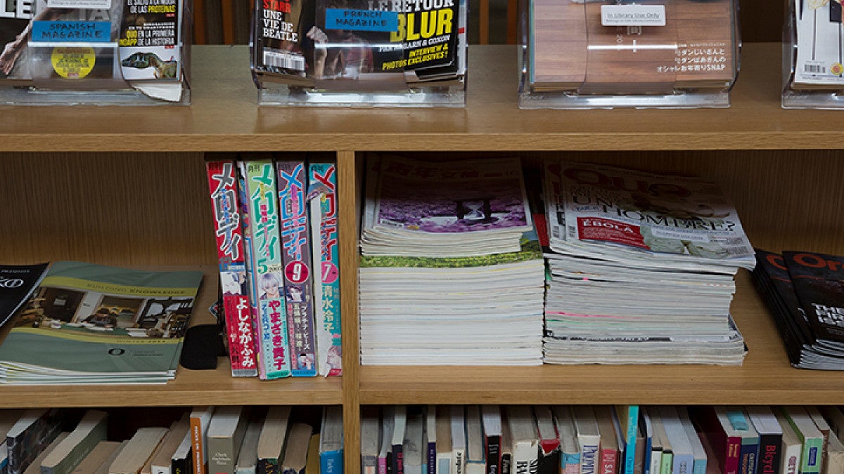 Stacked books arranged vertically and horizontally on shelves at varying levels.
