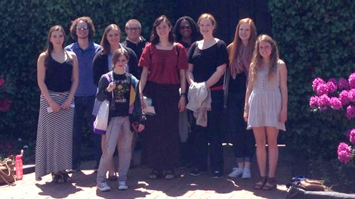 Group of students standing together in a courtyard.