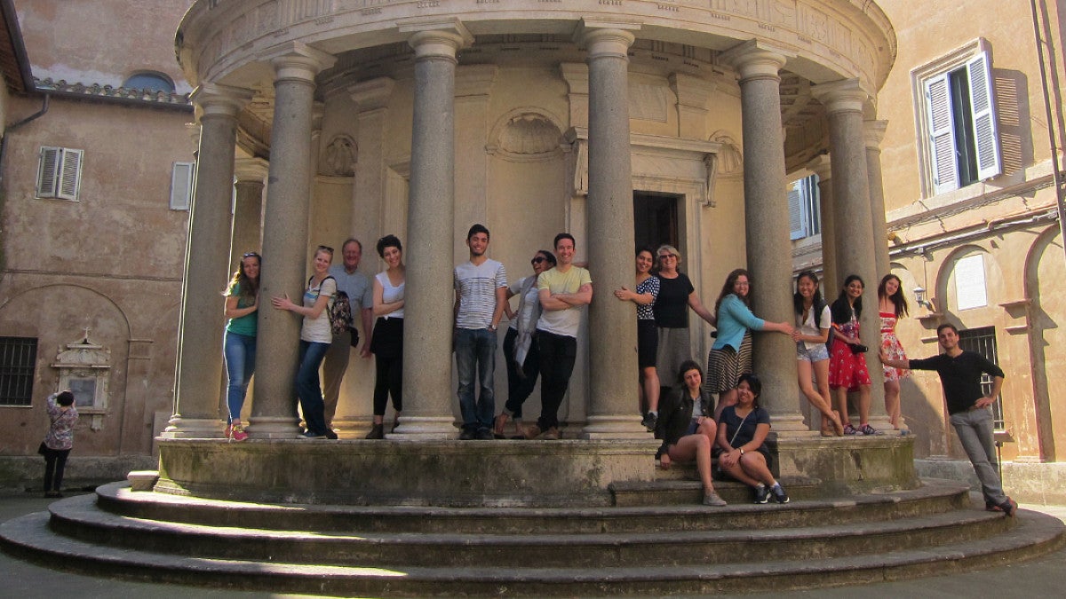 Students are sitting and standing around the Tempietto chapel in Rome, Italy.