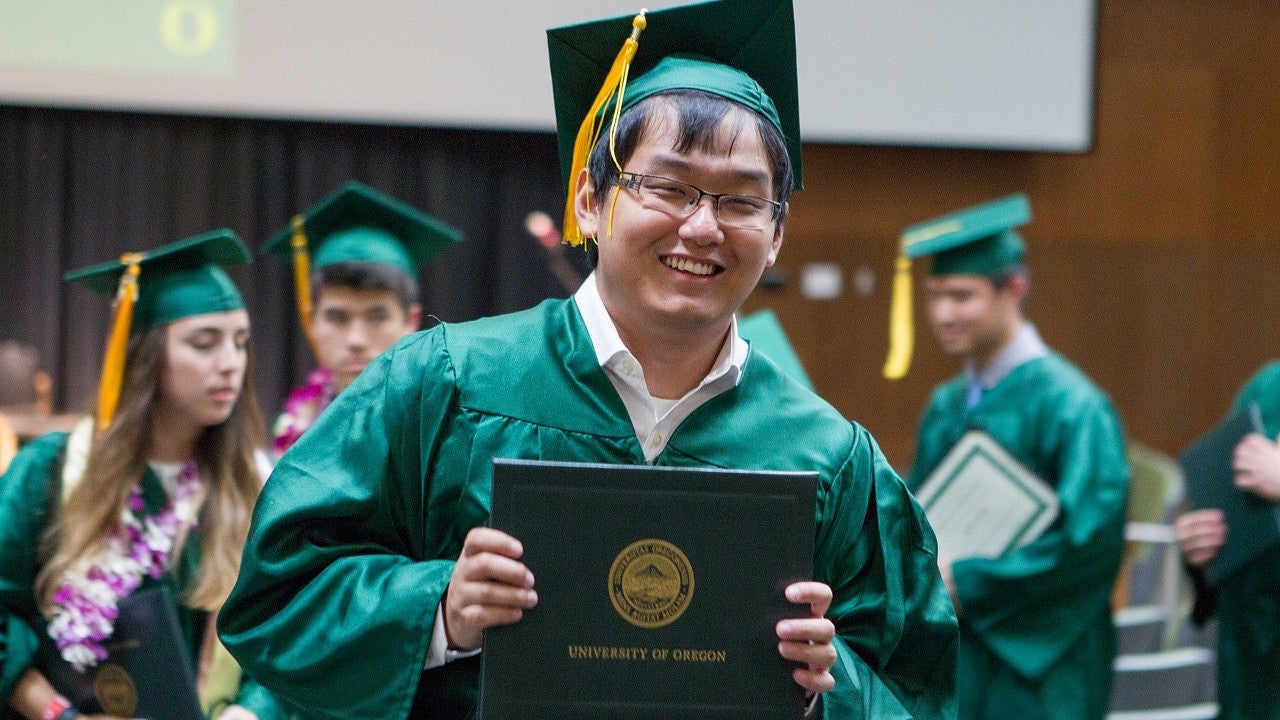 Graduate holding up diploma
