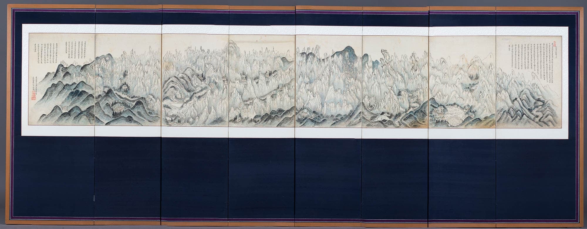Korean folding screen with painted mountains on blue backing material. 