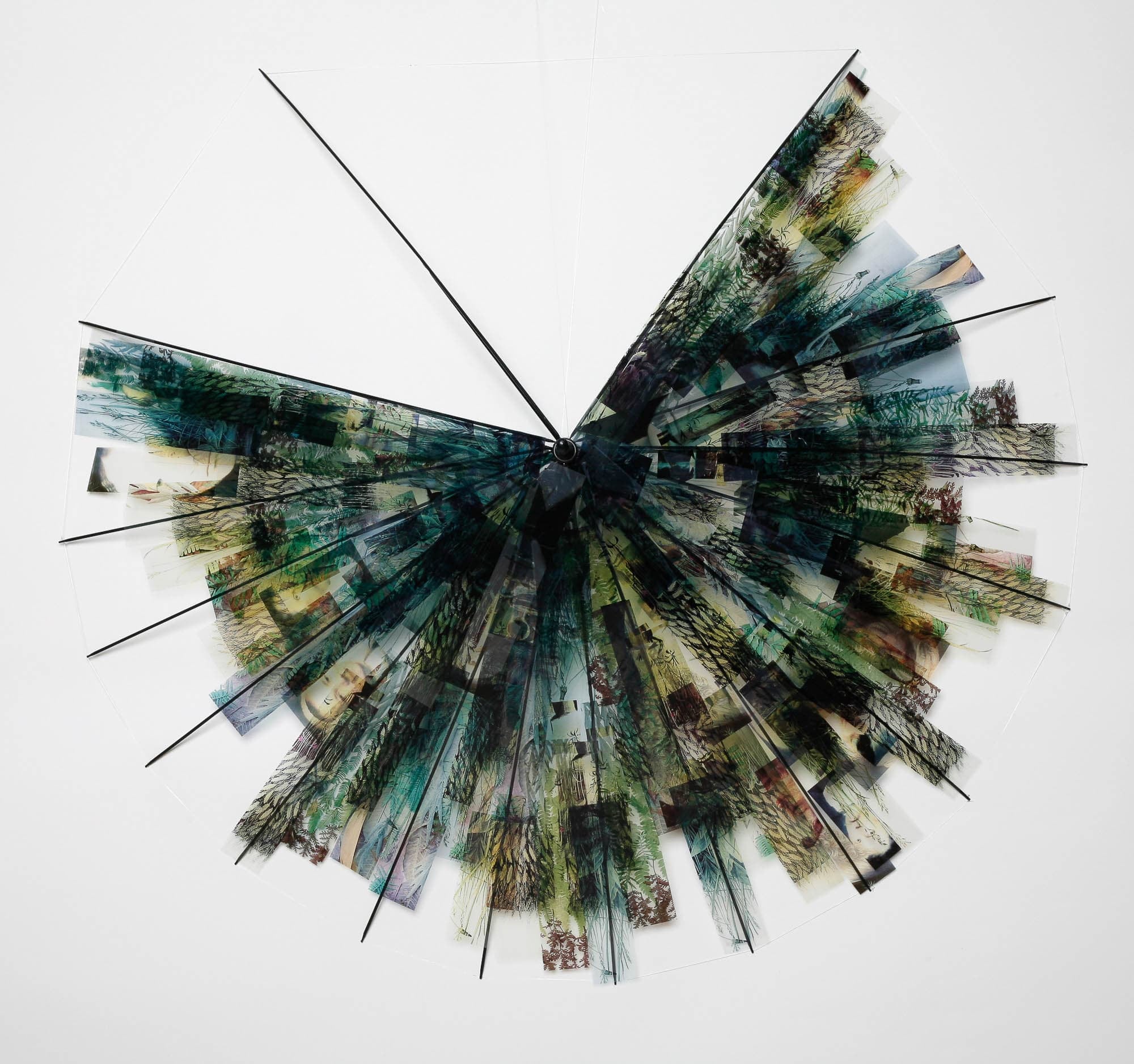 An umbrella made of film negatives against a white background. A portion of the umbrella is missing