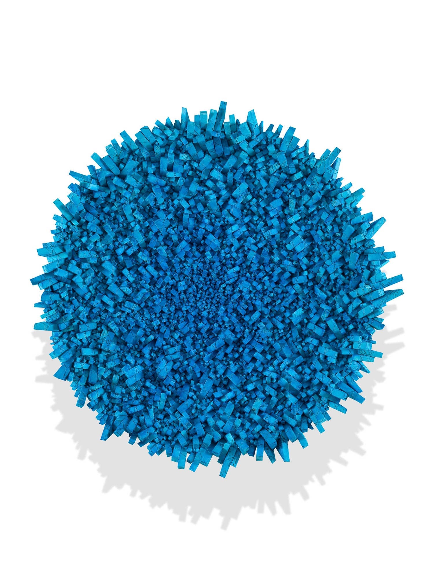 An abstract artwork featuring a dense cluster of blue geometric shapes in a circular formation, creating a textured surface.