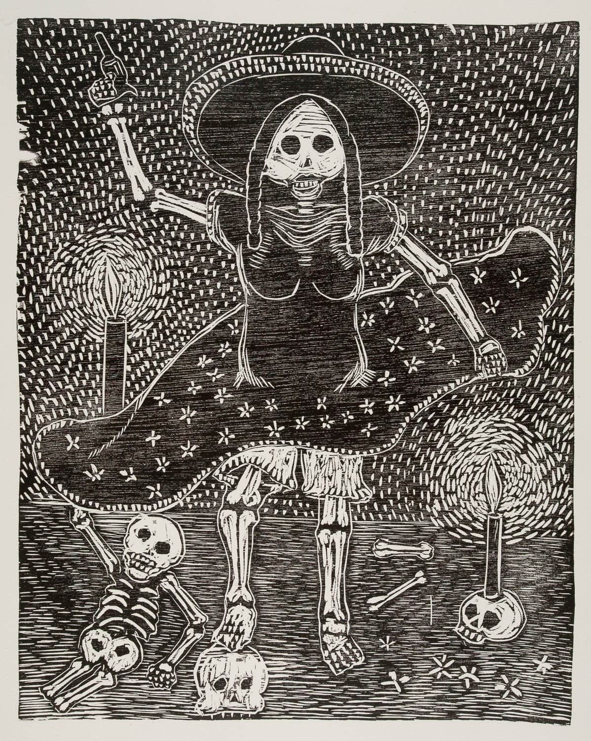 Black and white woodcut print of a skeleton woman with two braids wearing a sombrero and a dress with flowers on the skirt. One foot rests on a skull and one hand is raised with a gun. Two candles burn, one on a skull, the other held by a skeleton on the ground.