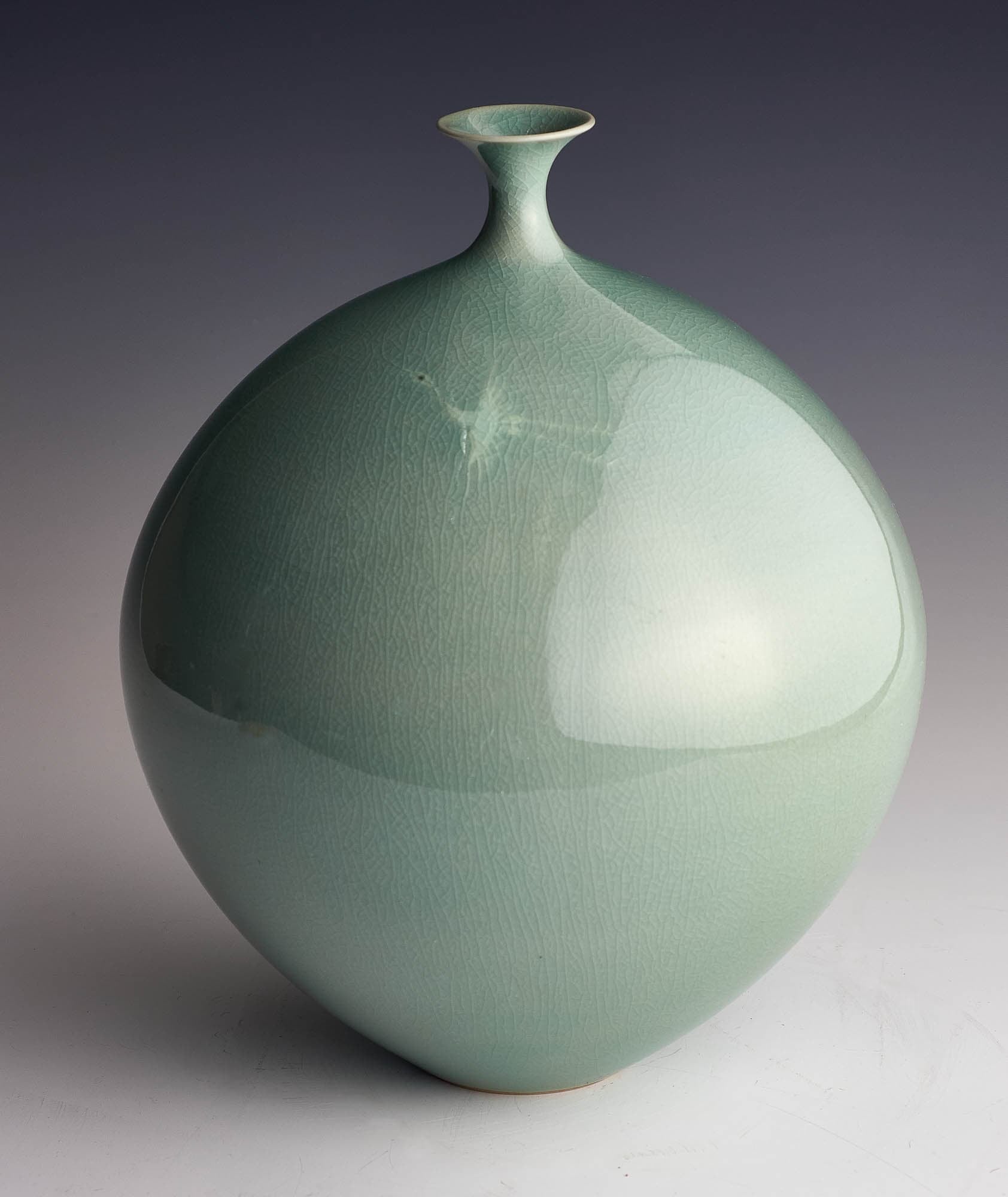 Round ceramic vase with short narrow neck and slightly flared lip with pale green glaze