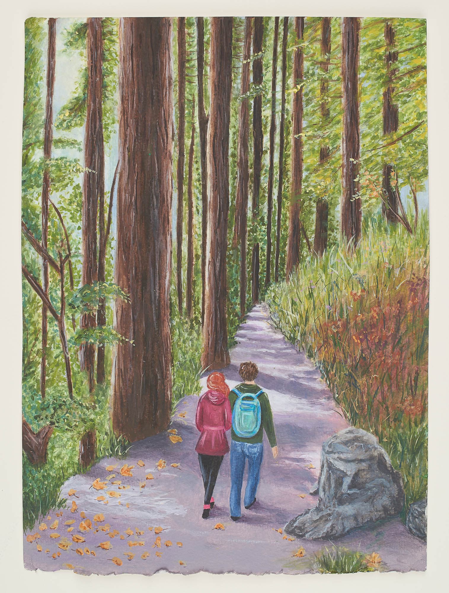 Two people viewed from behind walking down a forest path with tall trees on the right and green and red grasses on the right