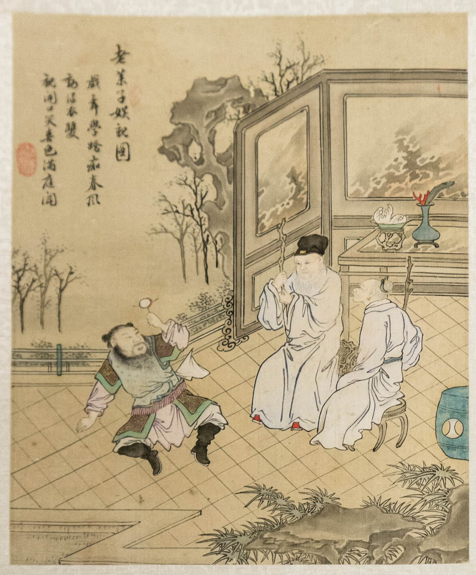 An elderly Chinese man and woman in white robes sit on stools while a younger man sits on the floor in front of them